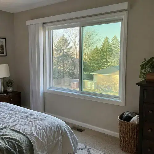 White sliding window with two panes in a bedroom wall