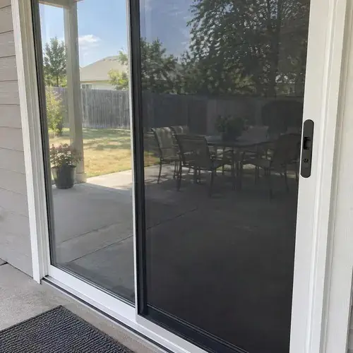 White-framed sliding patio door with handle lock and dark screen panel