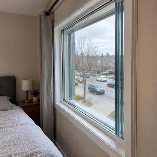 Large bedroom window with thick multi-layer glass looking onto a busy street