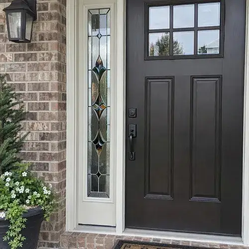 Leaded stained glass sidelight beside a dark entry door with glass top lites on